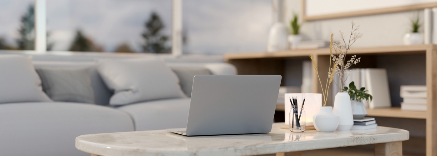 A laptop computer on a luxury white marble coffee table in a comfortable contemporary living room. A laptop computer on a luxury white marble coffee table in a comfortable contemporary living room. place of work concept. 3d render, 3d illustration